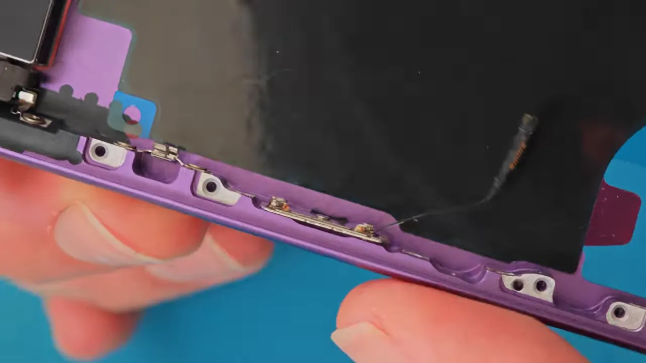 Main utilisant des pointes de soudage sur un petit support de bouton d'iPhone violet