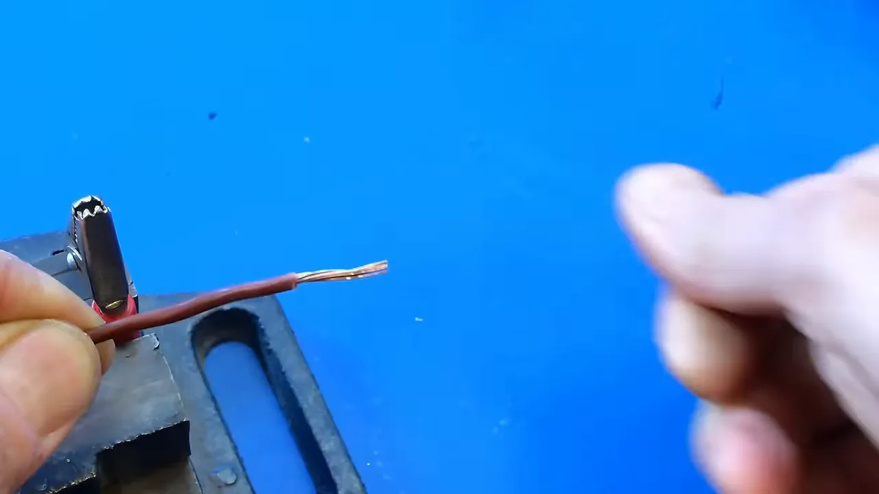 Fil électrique dénudé montrant des brins de cuivre propres prêts à être soudés