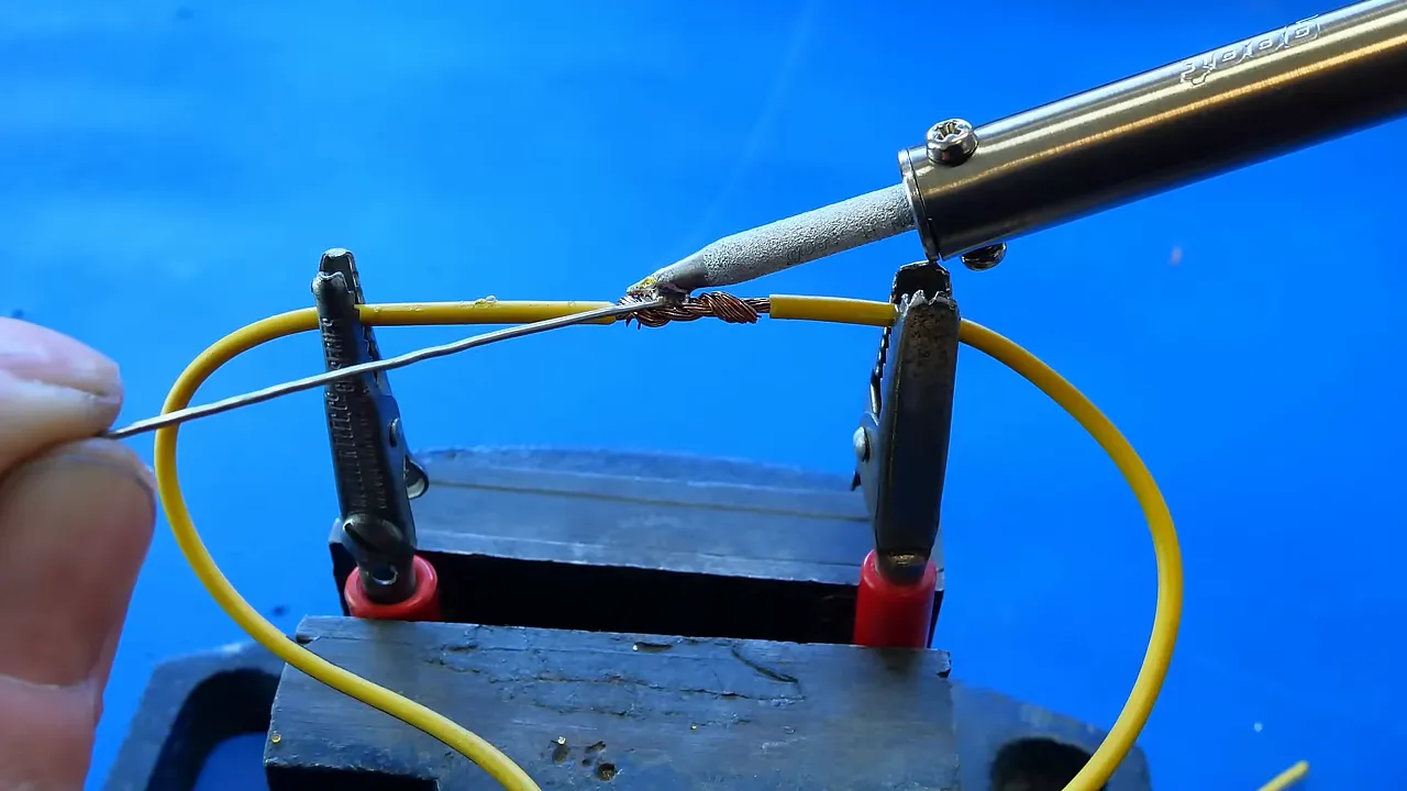 Étamage de la panne du fer à souder en appliquant de l'étain sur des fils torsadés