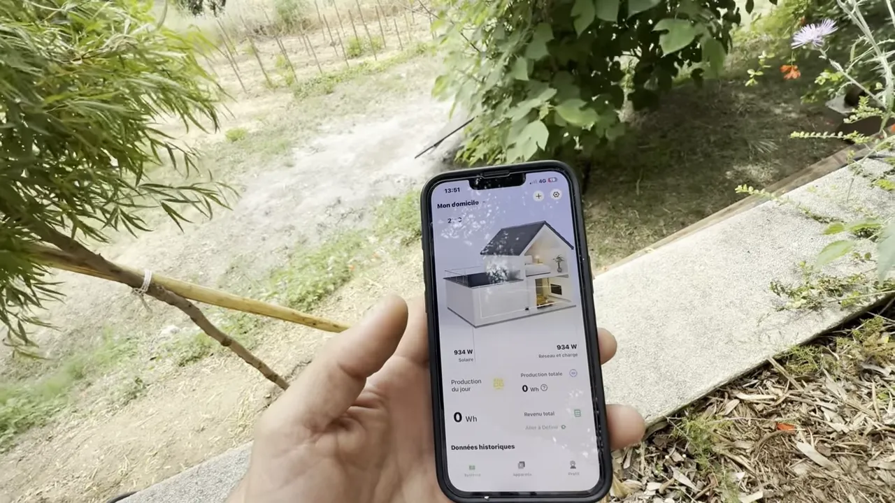 Téléphone affichant l'application de suivi de production solaire avec schéma de maison