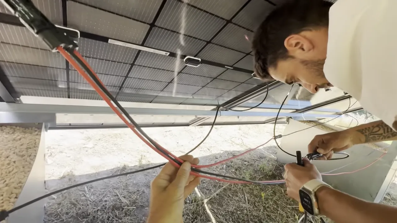 Câbles photovoltaïques et connecteurs fixés sous les panneaux solaires