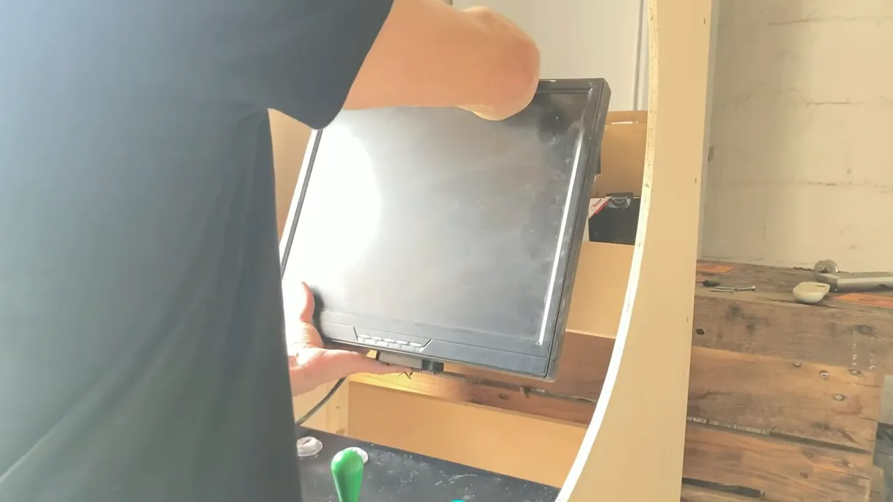 Visseuse en train de fixer l'écran sur sa planche de support