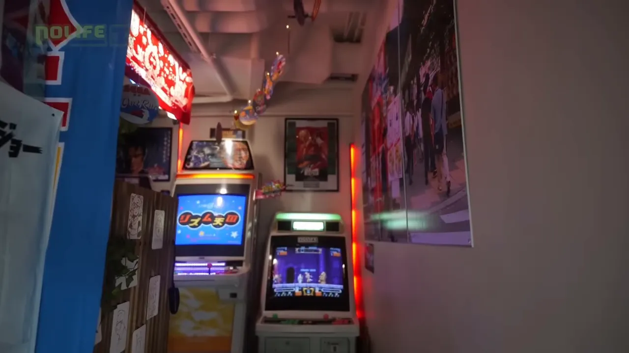 Mini-salle d'arcade avec bornes alignées, écrans allumés et affiches murales