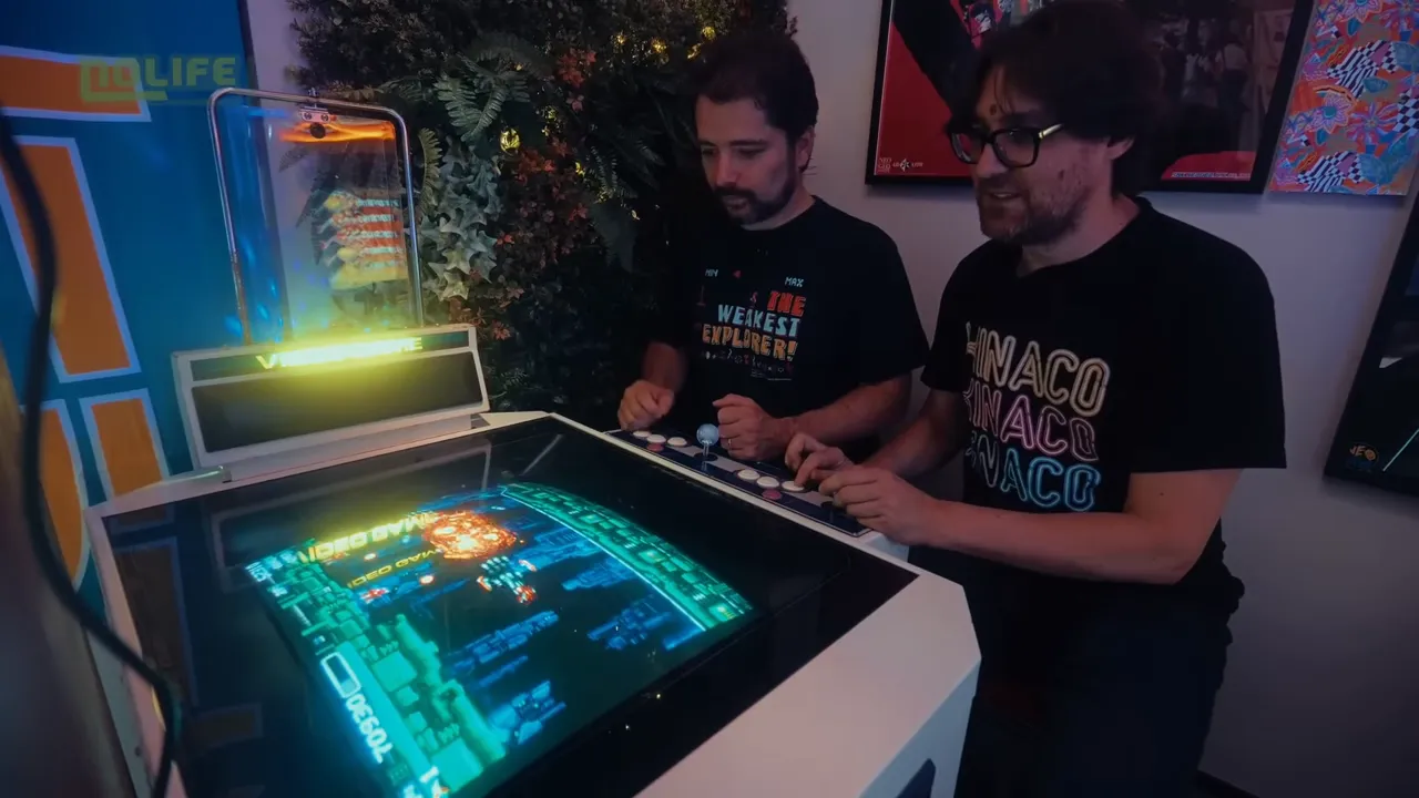 Deux joueurs souriants jouent ensemble sur une borne cocktail horizontale avec un jeu rétro affiché à l'écran