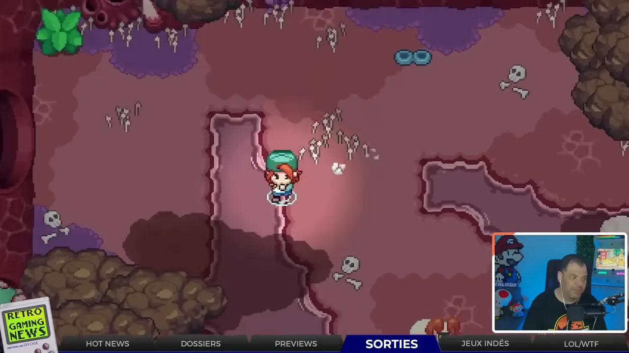 Capture d'écran de Under the Island montrant le personnage en exploration top‑down dans une caverne pixel art, image claire avec petit encart webcam en bas à droite
