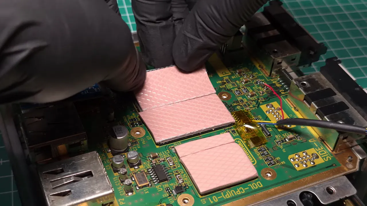 Pads thermiques roses posés sur les puces de la carte mère GameCube