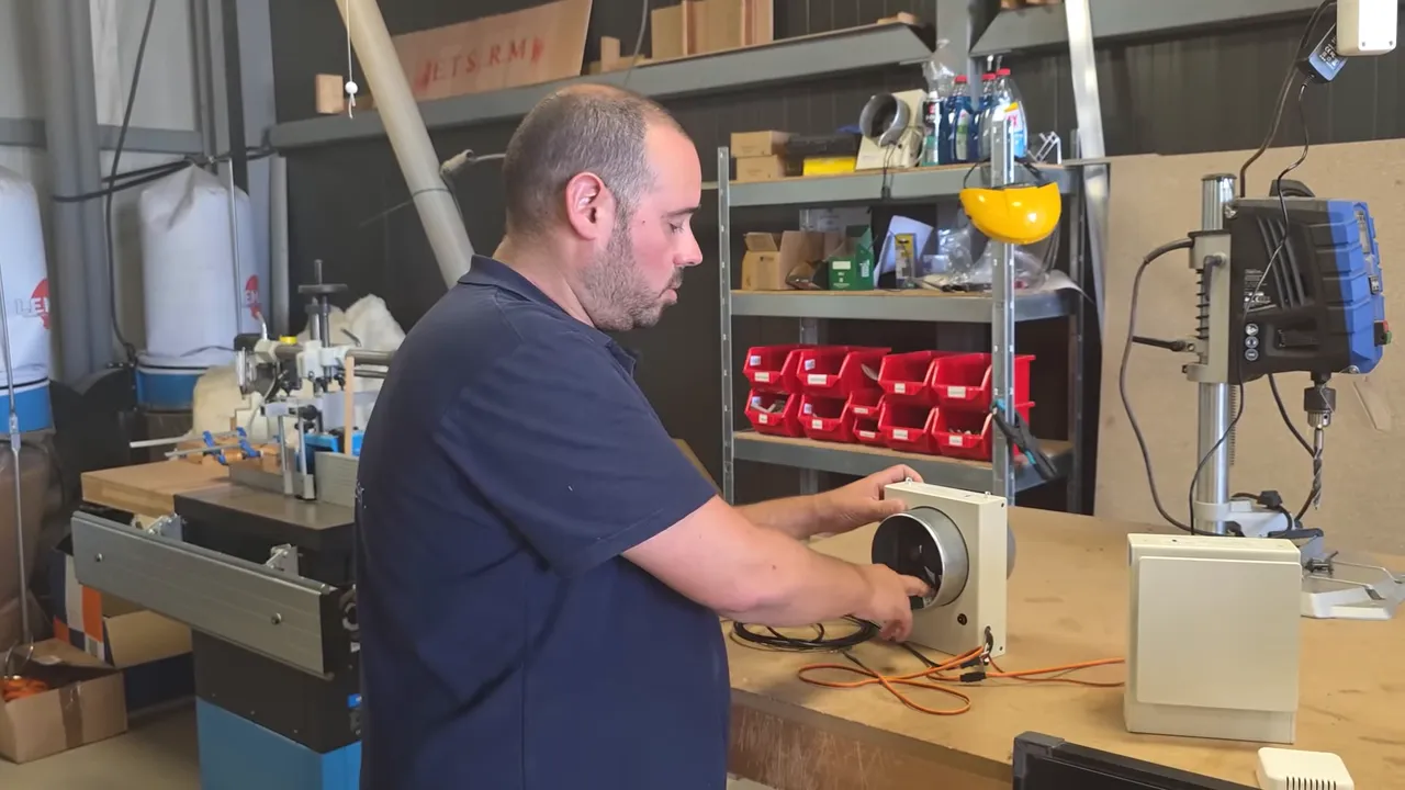 Technicien inspectant l'intérieur du boîtier de ventilation montrant le ventilateur, les câbles et les emplacements de capteurs