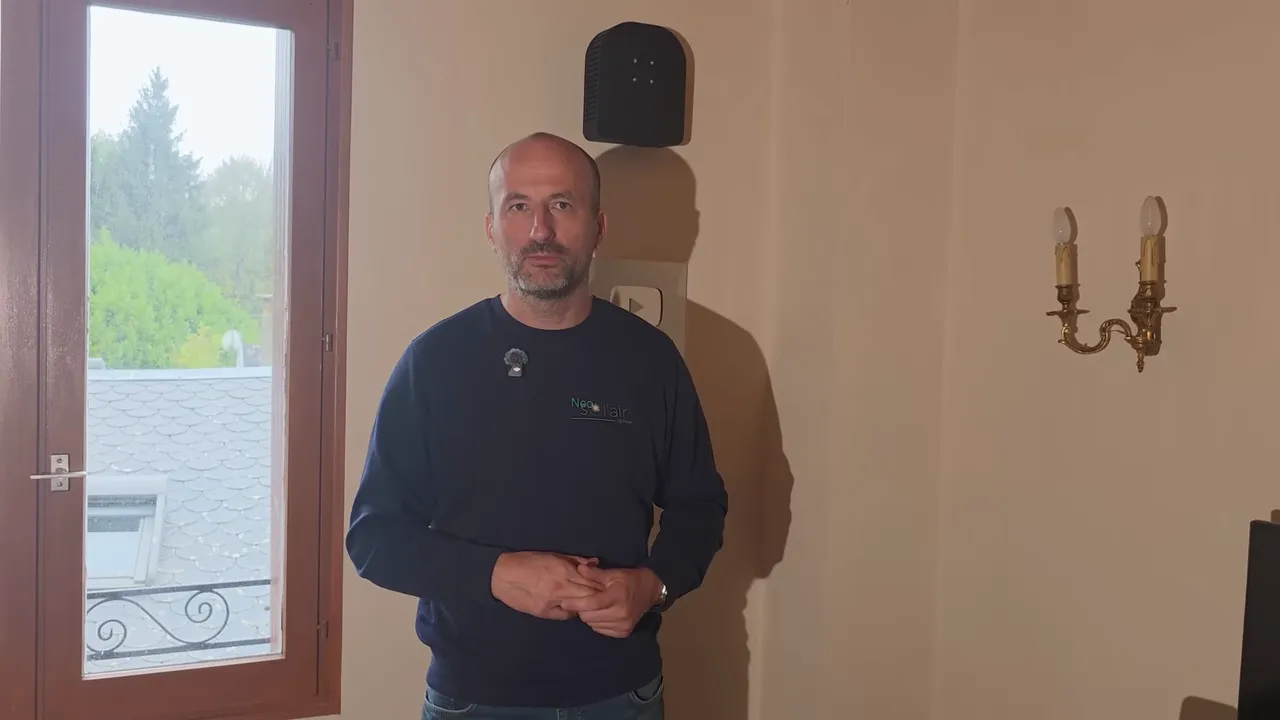 Présentateur centré regardant la caméra, expliquant la consommation électrique et le coût annuel