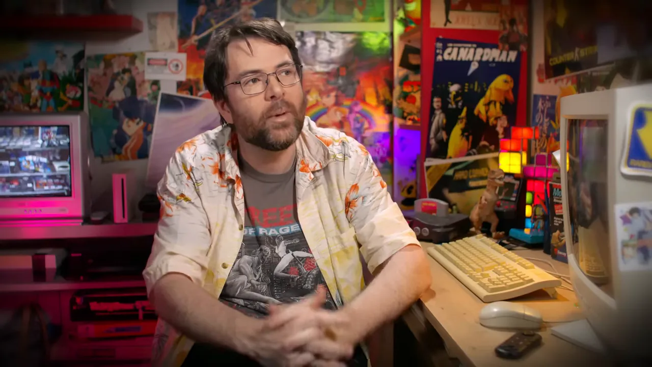 Présentateur assis devant un bureau avec clavier, écran CRT et objets de collection rétro