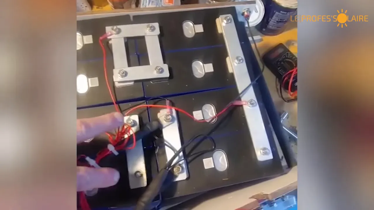 Busbar aluminium bricolé sur pack LFP avec fils rouges et noirs et multimètre
