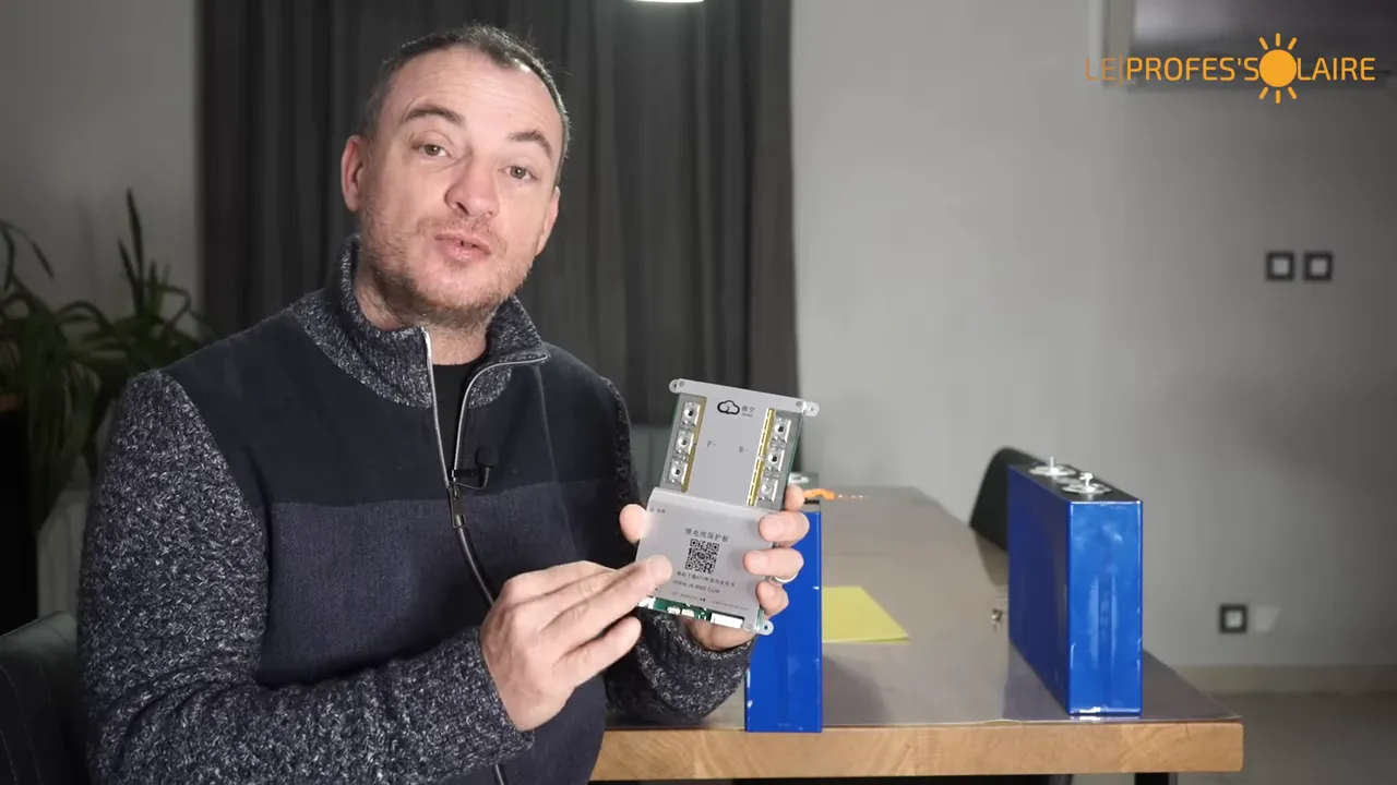 Module BMS tenu à la main devant deux cellules LFP, démonstration du composant