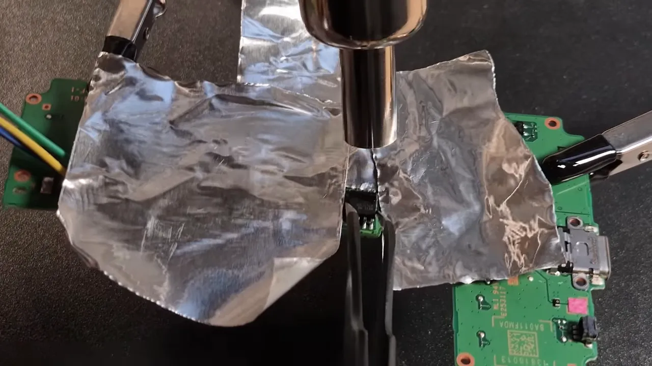 Carte mère de la Game & Watch protégée par du scotch aluminium pendant le chauffage