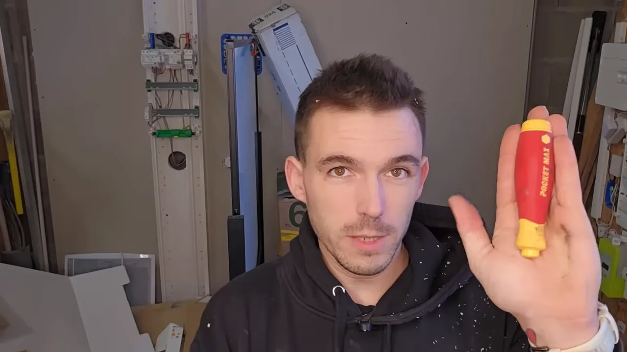 Gros plan du tournevis Pocket Max Wiha rouge et jaune tenu verticalement devant la caméra