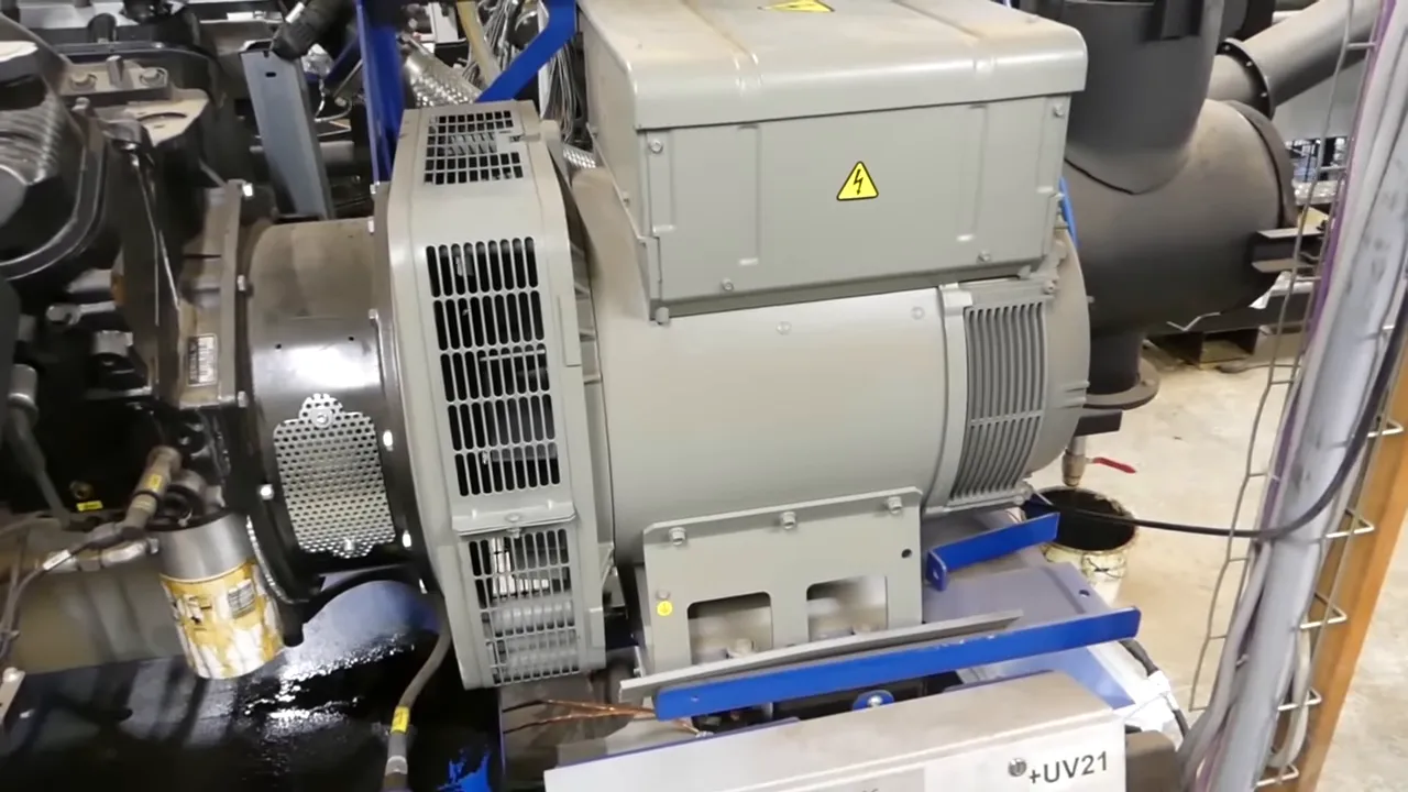 Génératrice électrique grise accouplée au moteur dans la chaufferie