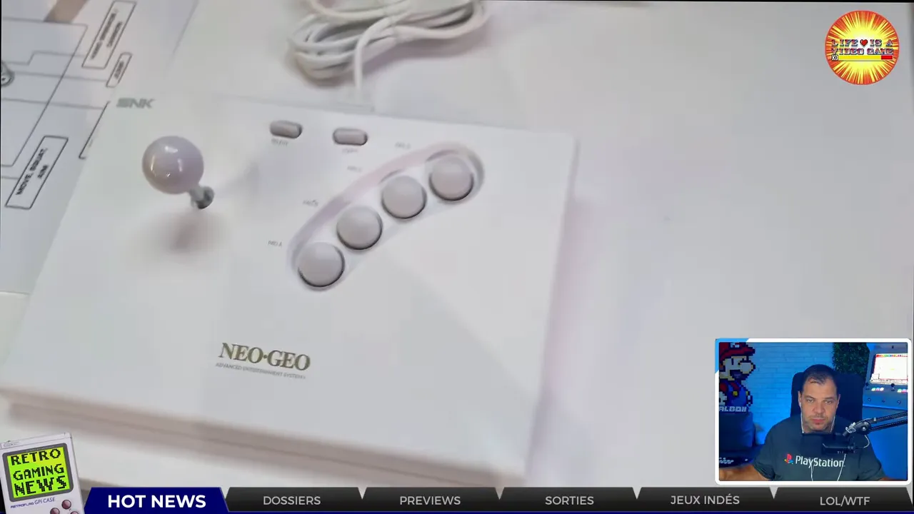 Console Neo Geo blanche et manette blanche installées devant un écran SNK