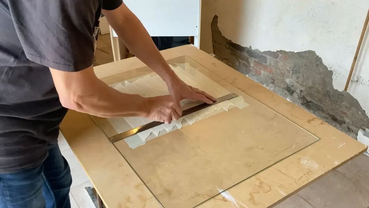 Découpe propre du film de masquage au cutter pour délimiter la zone à peindre