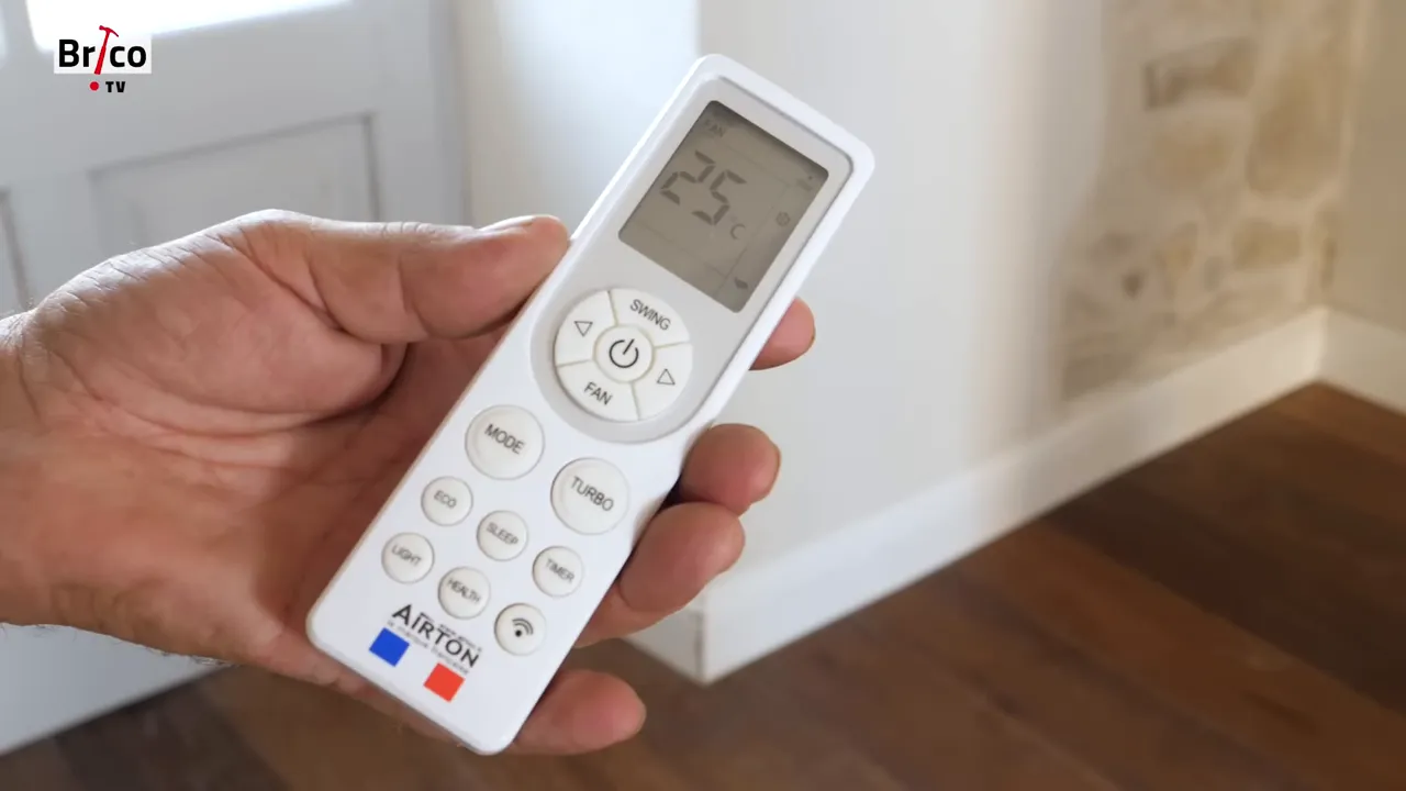 Télécommande blanche de climatiseur affichant la température et les boutons de commande