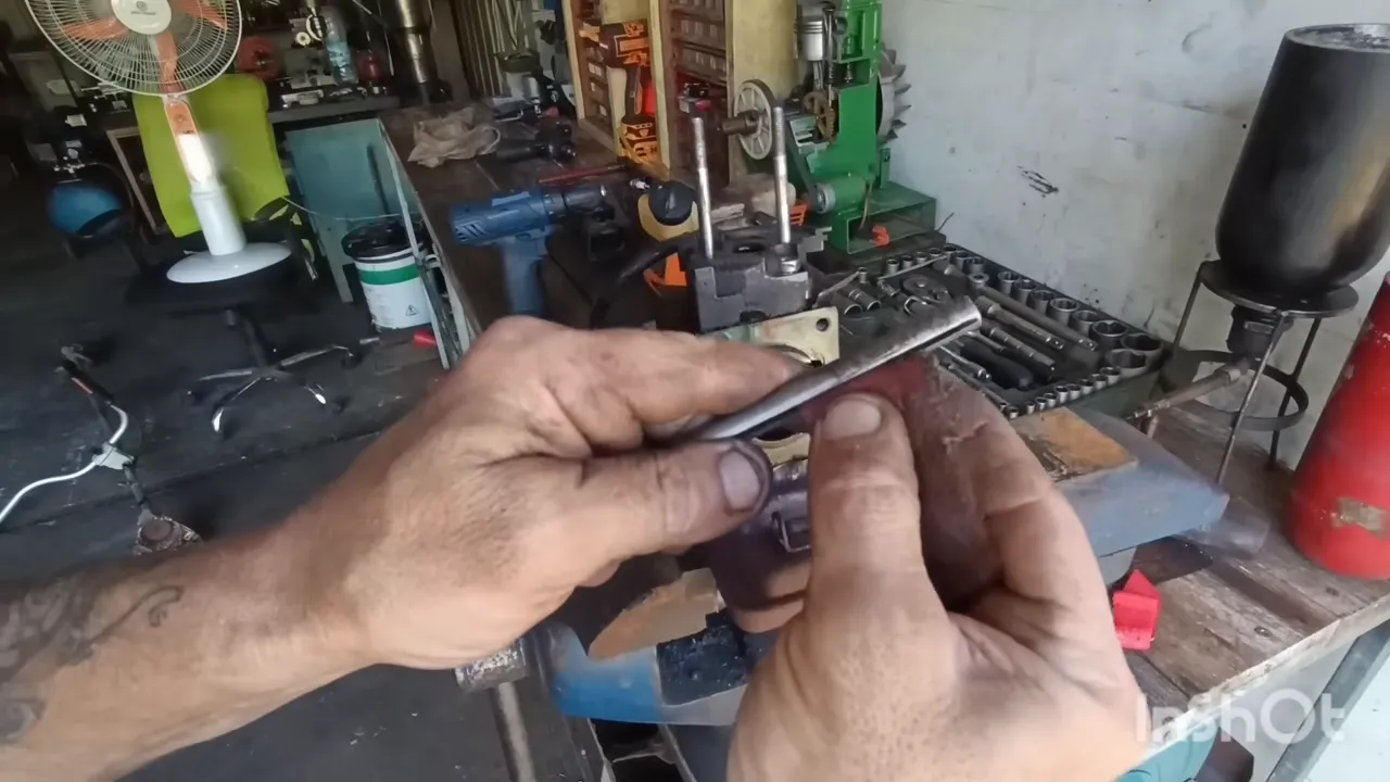 Positionnement de l’outil de déglaçage devant l’ouverture du cylindre moteur de débroussailleuse