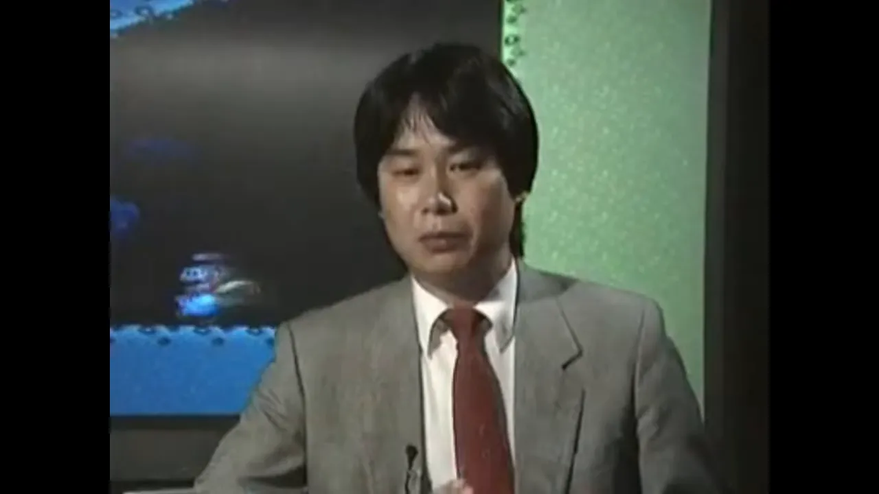 Shigeru Miyamoto en interview devant un écran de jeu Mario