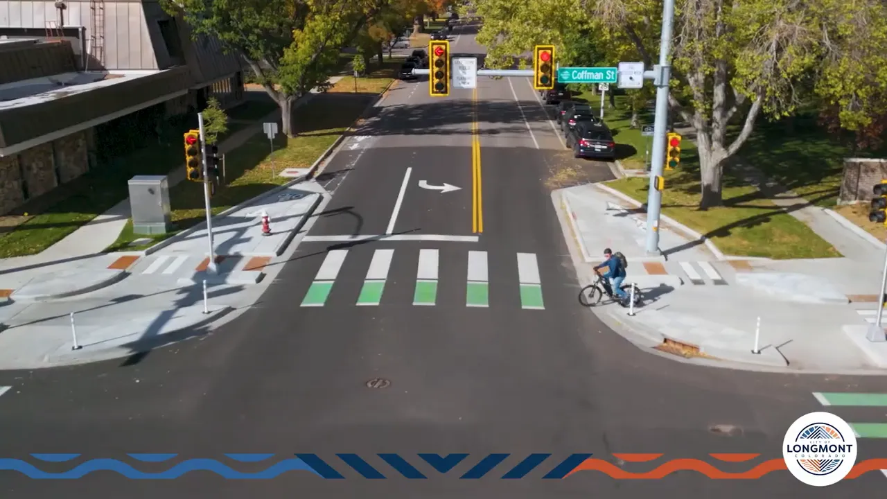 Aerial view of intersection with cyclist staged at corner island and green bike crossing illustrating two-stage left turn