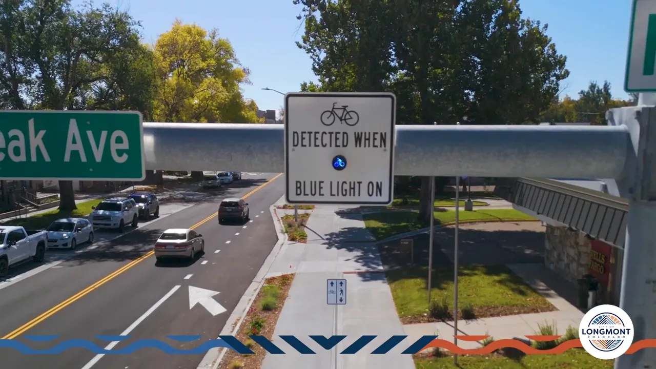 Bicycle detection sign with illuminated blue light over the roadway that indicates a bike has been detected.