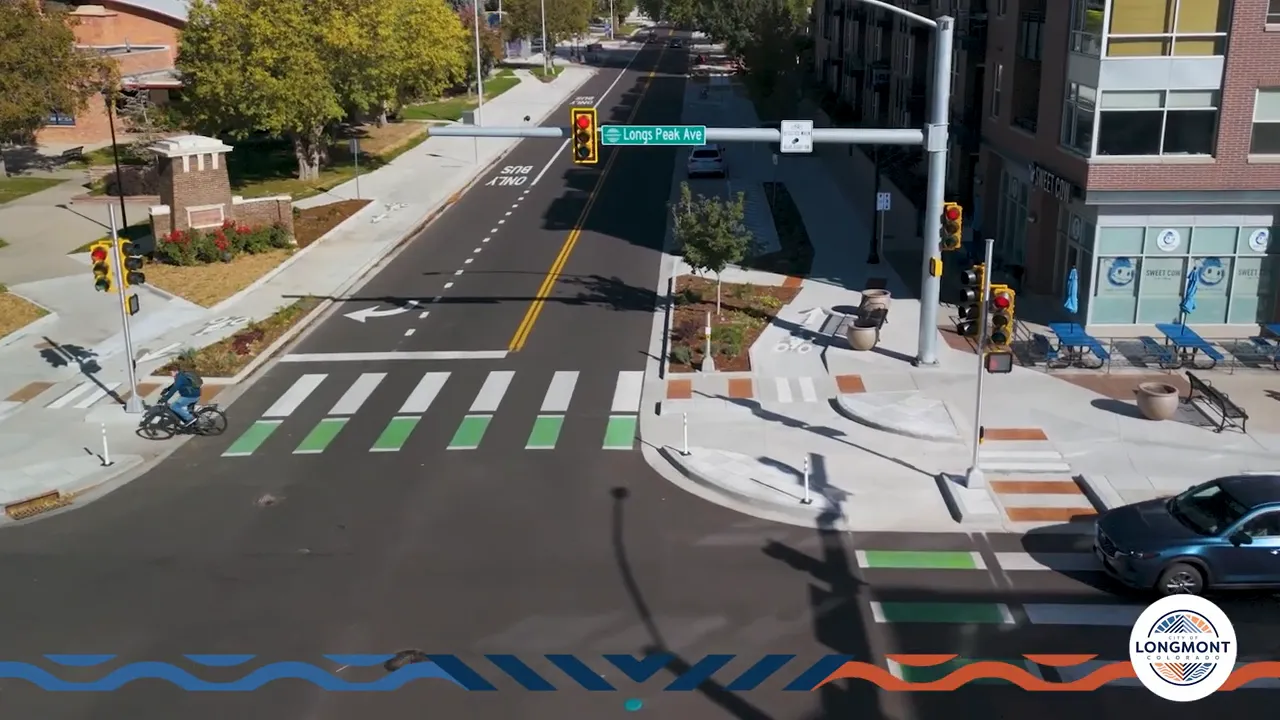 Drone view of a protected intersection showing corner islands, dedicated bike lanes, green bike crossings and pedestrian crosswalks.