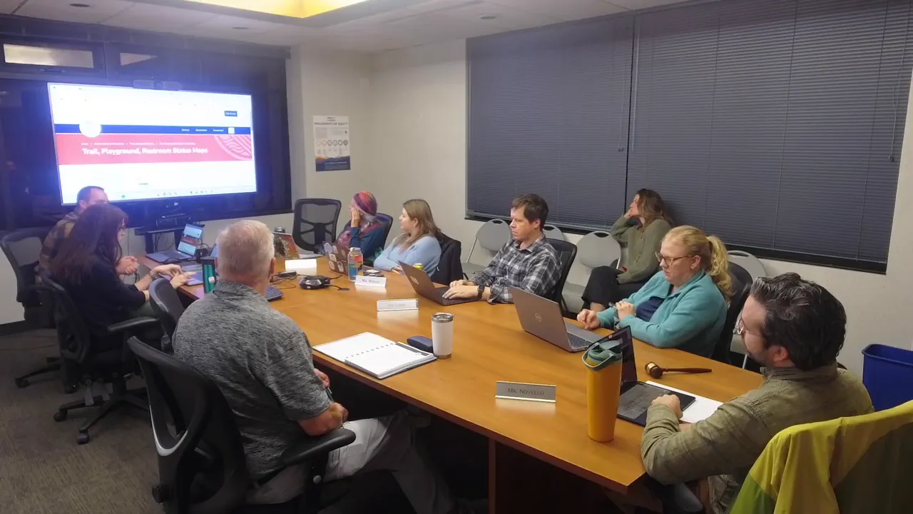 Parks advisory board meeting with a clear view of the TV displaying the park status map banner