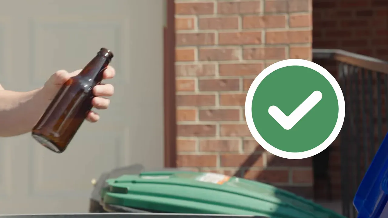 Where Does My Recycling Go? A Longmont Guide to Recycling Right 2 hand holding a clean glass bottle over a curbside recycling cart with a green check mark indicating it's recyclable