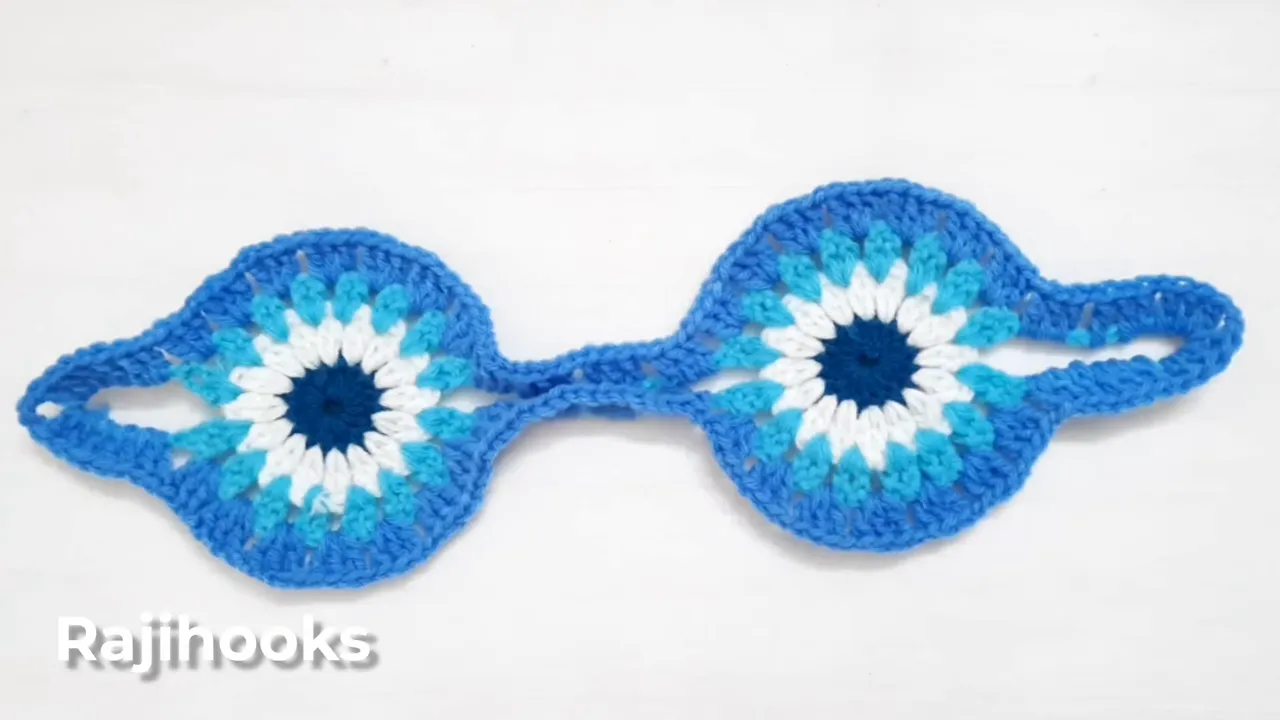Connected blue and turquoise crochet motifs with a blue border around the circles, bridges, and end loops