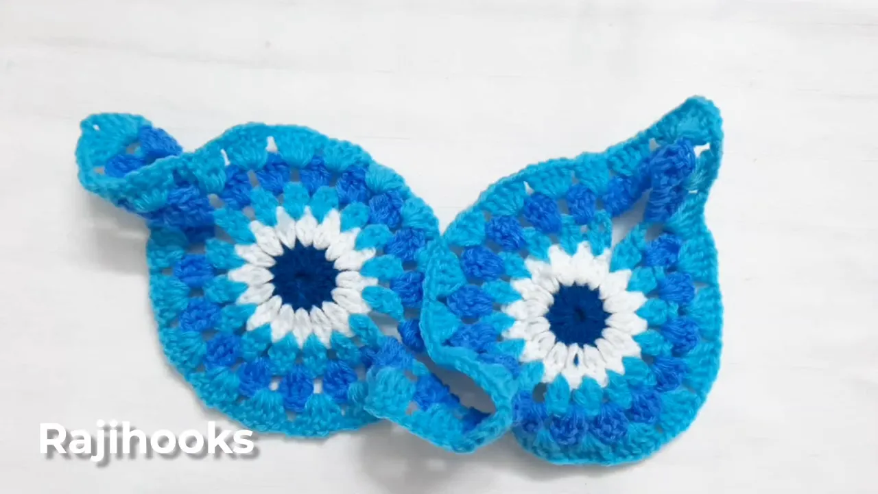 Two connected crochet motifs with turquoise outer stitch groups and curled connecting sections