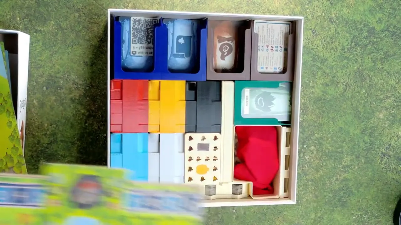 Geöffnete Emberleaf Schachtel mit farblich sortierten Einsätzen, Kartenhaltern und Spielerboxen
