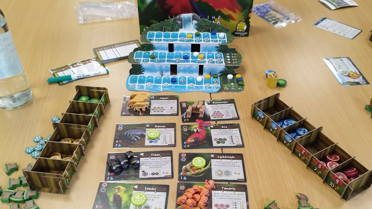 Life of Amazonia Spielaufbau mit Karten, Holz-Tokens, Tableaus und Spielbox