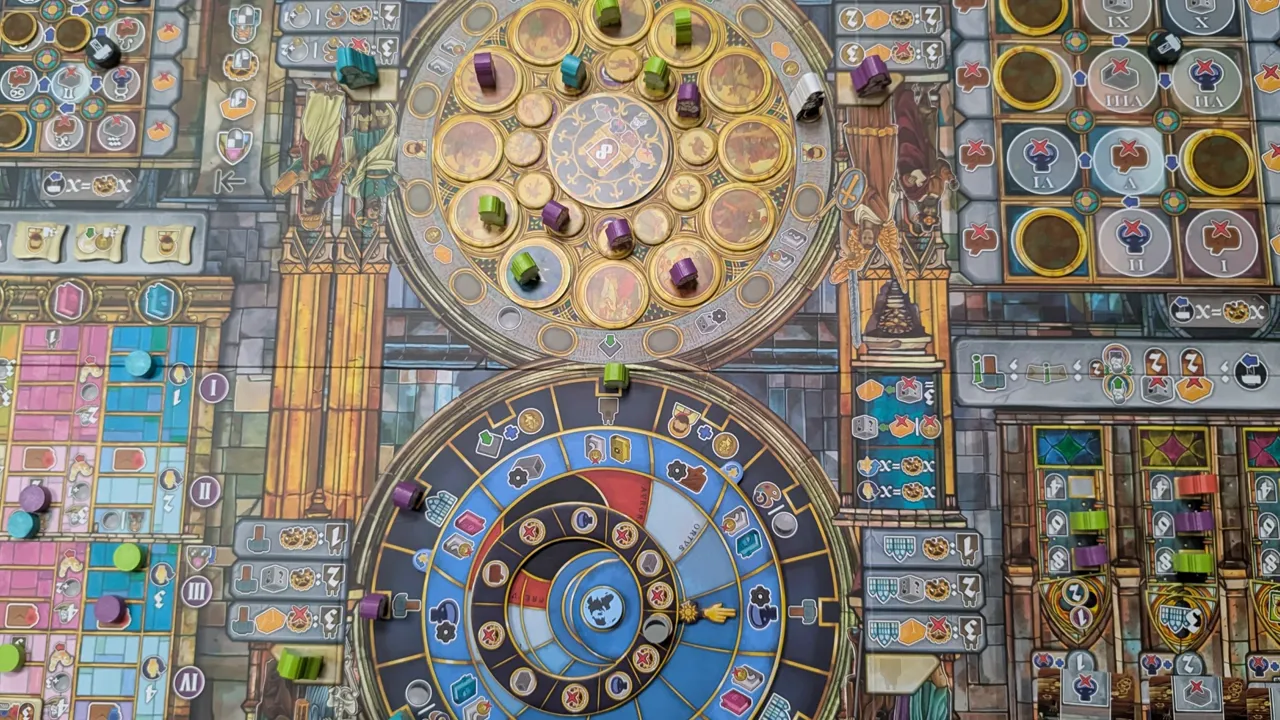 Nahaufnahme des Orloj Spielbretts mit zwei rotierenden Ziffernblättern und Spielsteinen