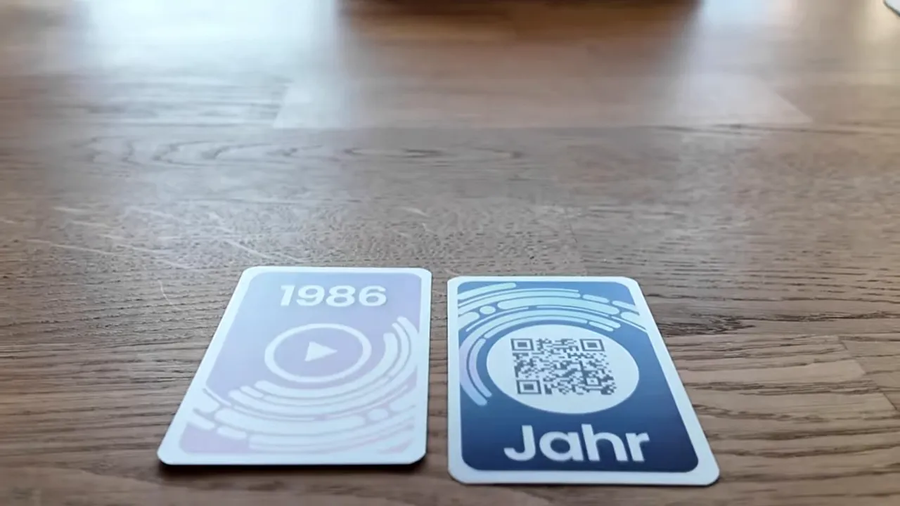 Offene Jahreskarte 1986 neben einer verdeckten Jahreskarte mit QR-Code