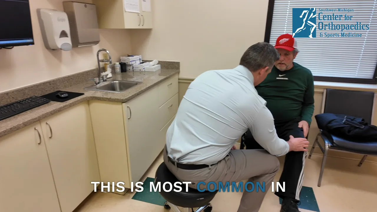 Clinician examining a patient's knee during a sports medicine visit
