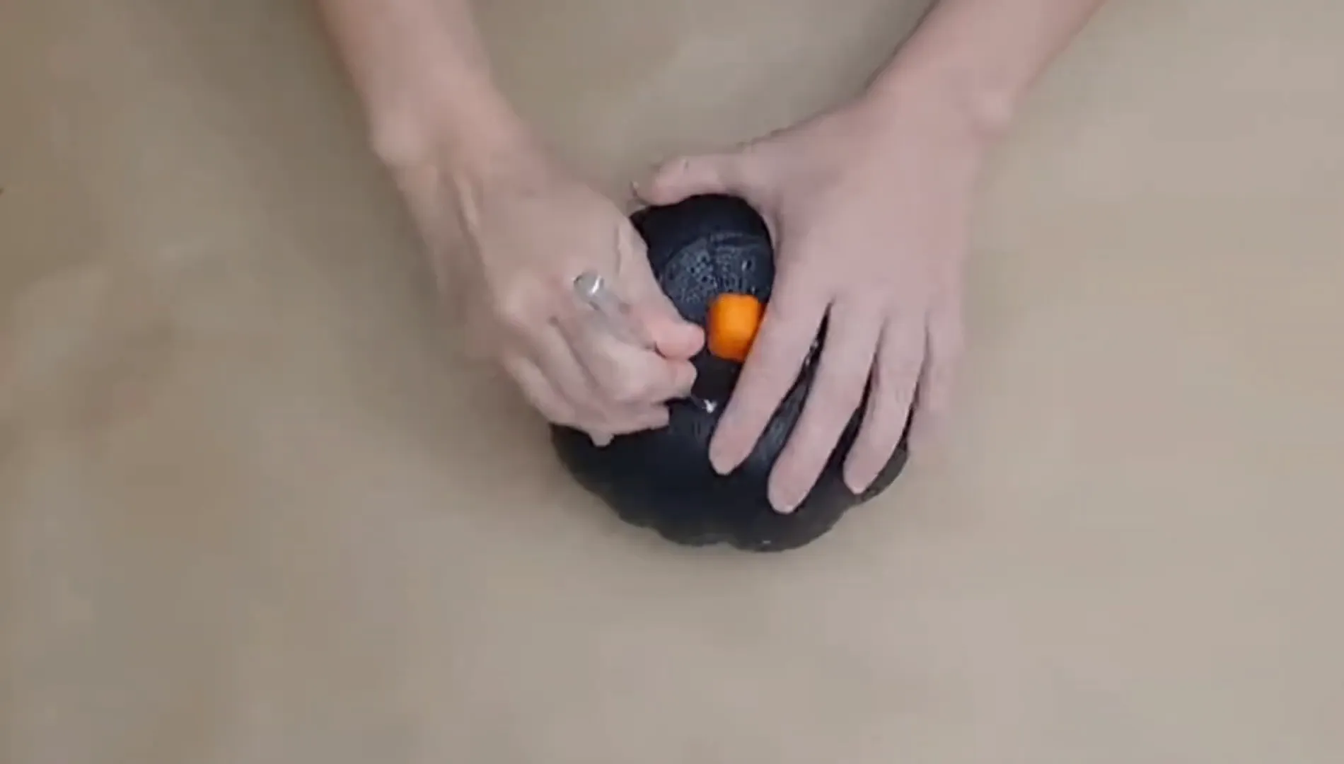 Cutting the top off the pumpkin.