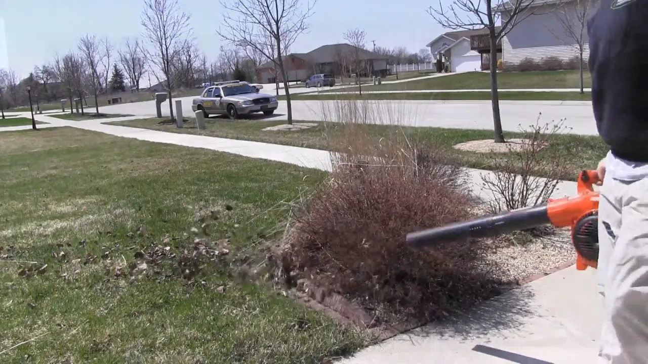 Clearing bed edge debris with a leaf blower and pushing it onto the lawn