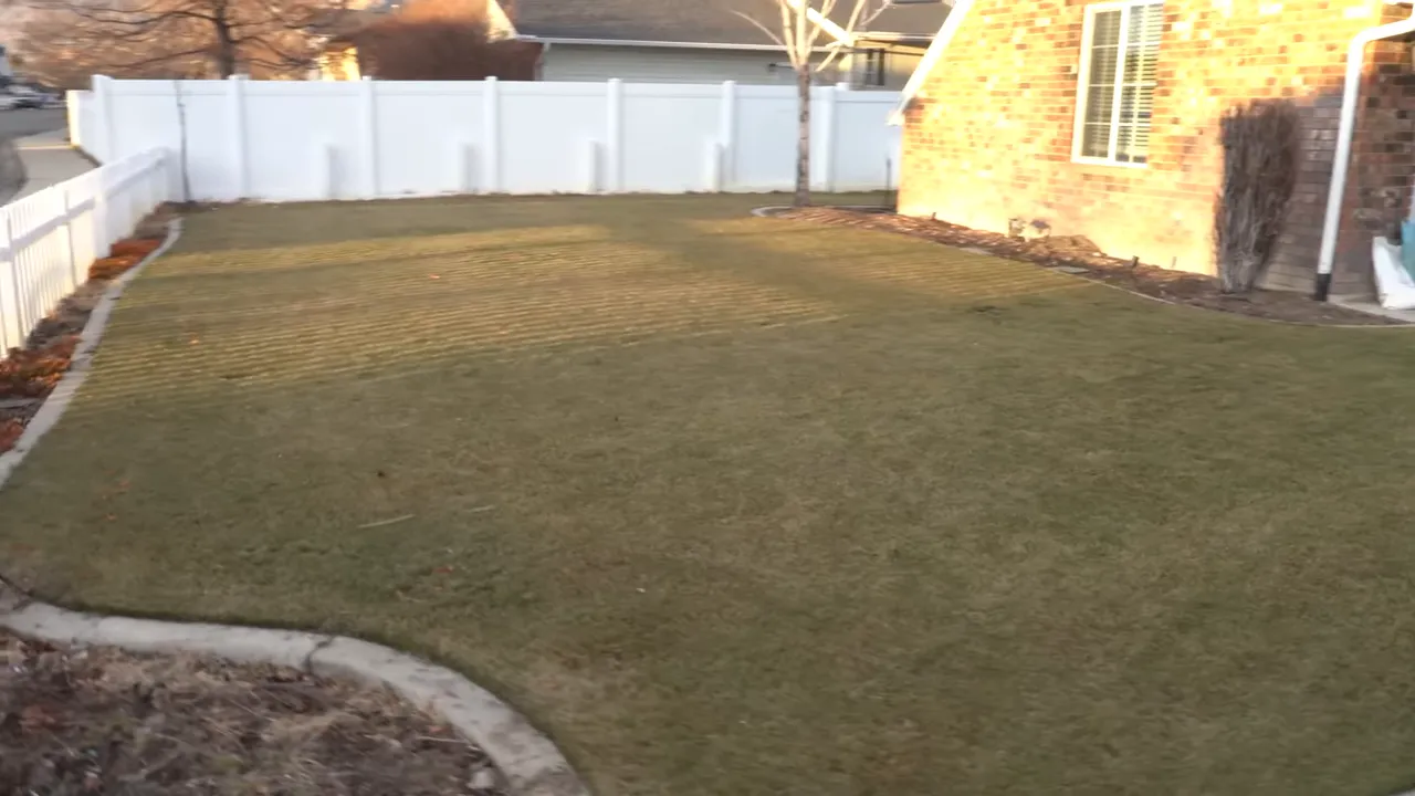 Wide view of a brown spring lawn in front of a house