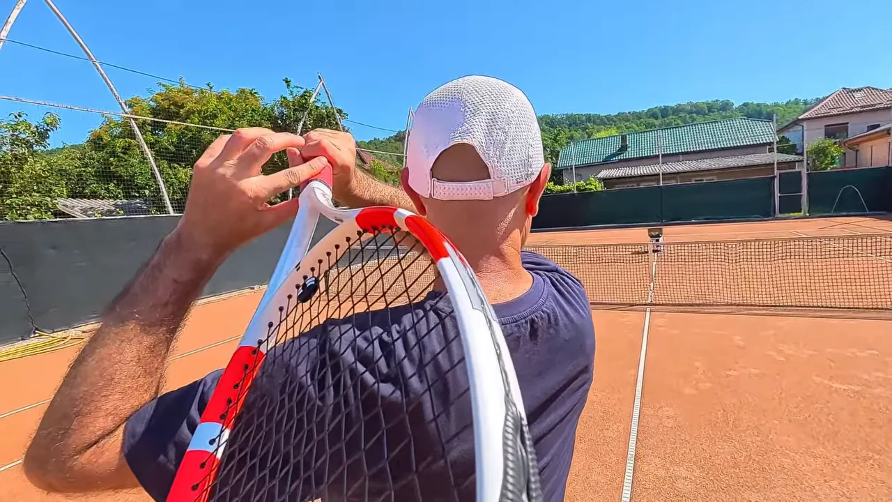 Close view of racket finishing over the non-dominant shoulder