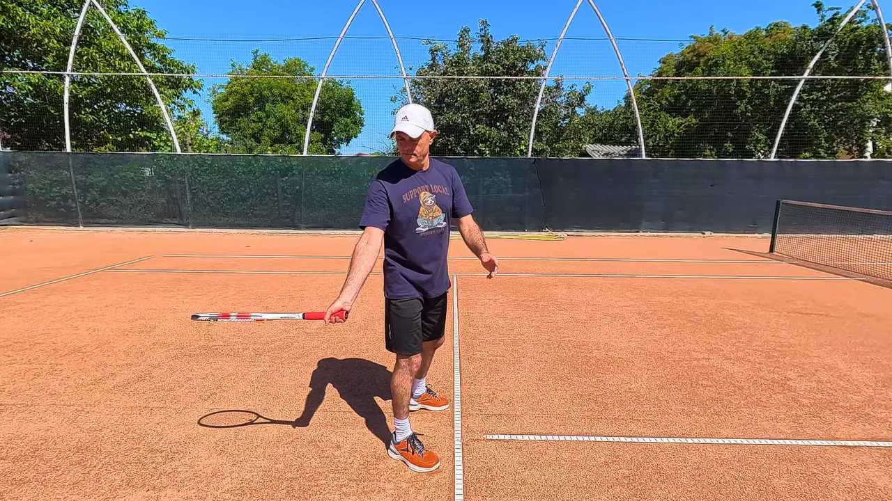 Player holding racket back low with strings facing down