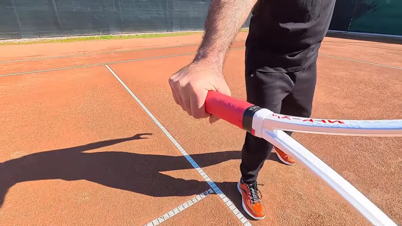 close-up of a hand holding a tennis racket handle to show grip position
