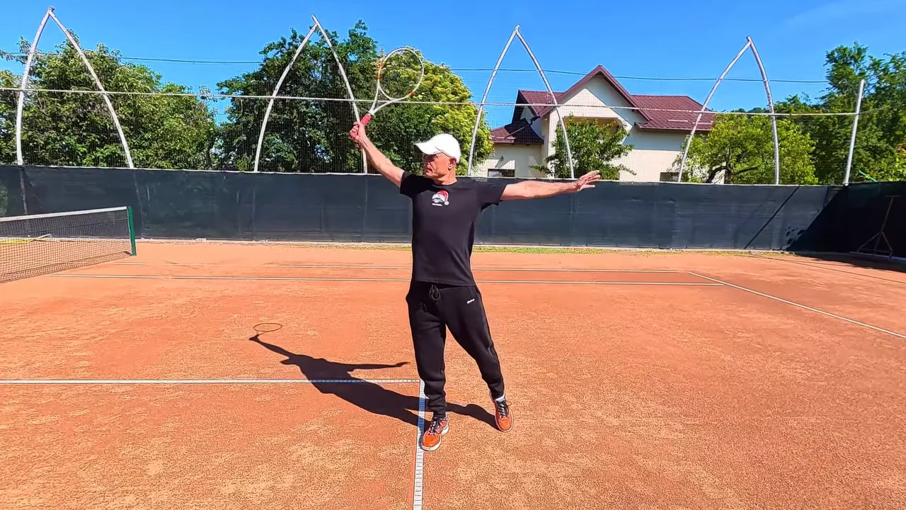 player at service line finishing a one-handed backhand with racket high and arms spread