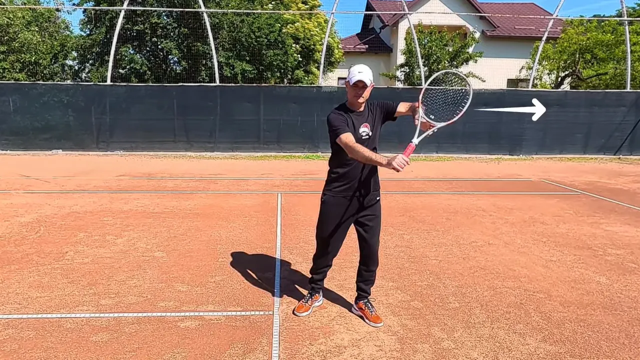 player in sideways preparation position with racket set high for a one-handed backhand