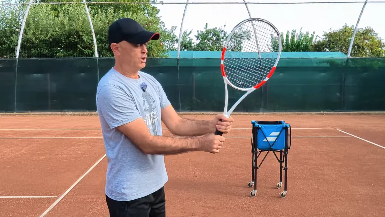 Coach holding a tennis racket with both hands together on the handle