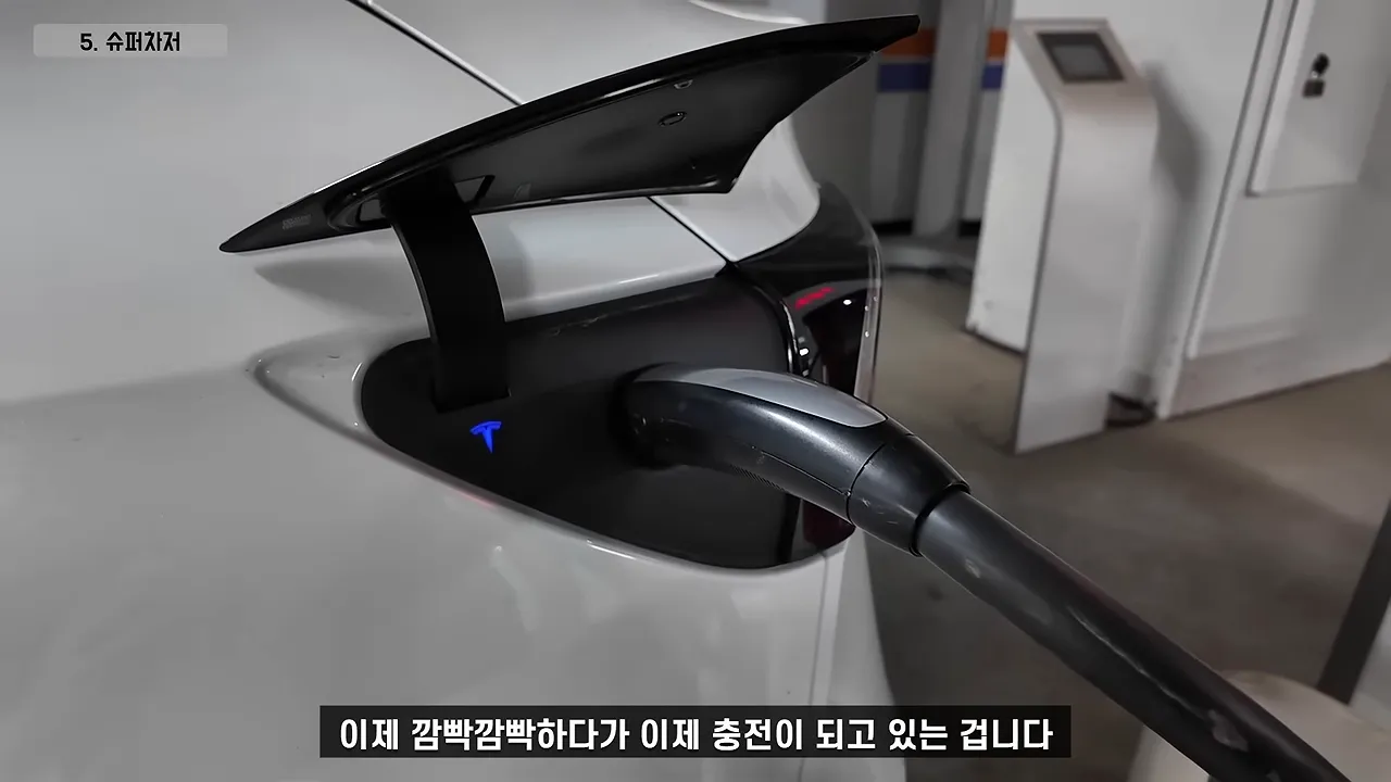 테슬라 차량 충전 포트에 슈퍼차저 커넥터가 연결된 모습