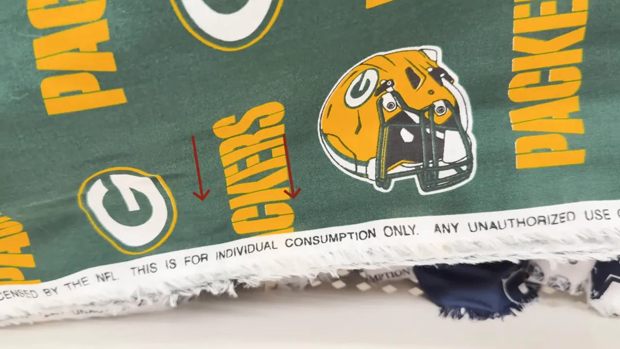 Close-up of Green Bay Packers fabric selvage reading 'THIS IS FOR INDIVIDUAL CONSUMPTION ONLY' with team logos above