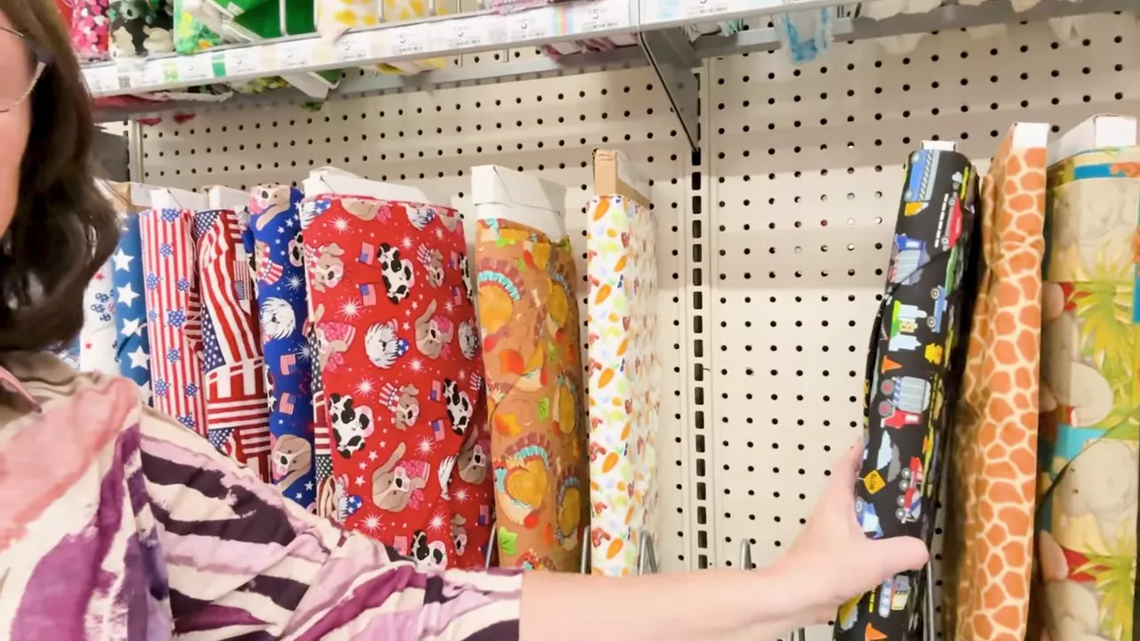 Row of fabric bolts showing a variety of generic prints and patterns on store shelving
