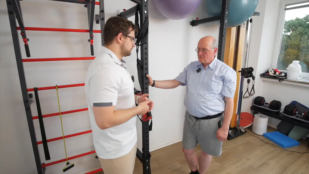 Physiotherapeut erklärt Patienten, wie die Beckenkippung im Alltag angewendet wird