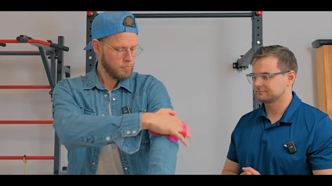 Moderator massiert seinen Unterarm mit dem pinken Massagehandschuh