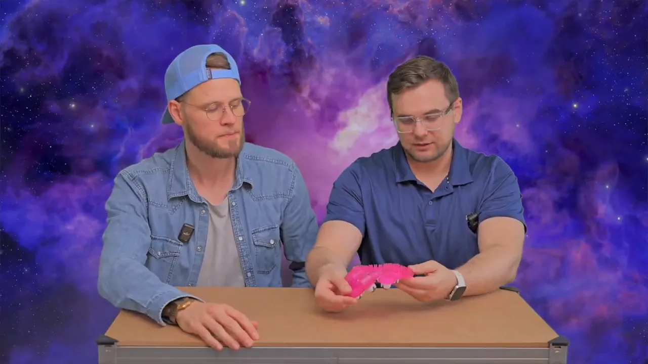 Moderator hält den pinken Massagehandschuh und zeigt die drehbaren Kugeln